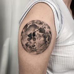 a man with a bicycle on his arm in front of a full moon tattoo design