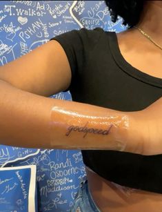 a woman with a tattoo on her arm that reads, goodland and has writing all over it