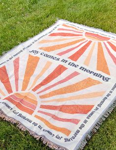 an orange and white blanket laying in the grass