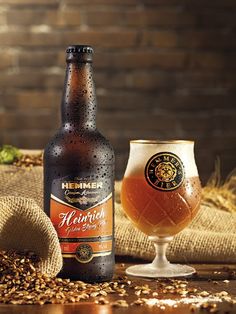 a bottle of beer next to a glass full of beer on a table with burlocks