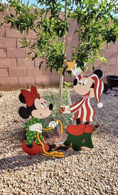 mickey and minnie mouse in front of a potted tree with a birdcage