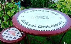 a table and two stools sitting in the grass