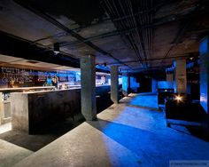 a dimly lit bar in an empty room with blue lights on the walls and floor