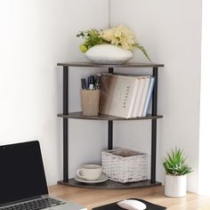 a laptop computer sitting on top of a wooden desk next to a book shelf filled with books