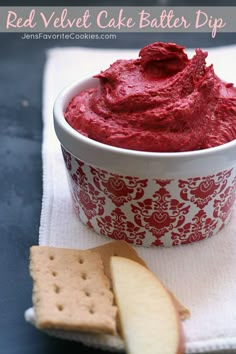 a red dip in a bowl with crackers on the side