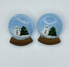 two snow globes with trees in them