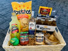 a basket filled with condiments and drinks on top of a carpeted floor