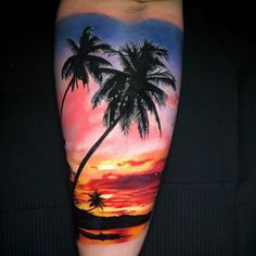 a man's arm with a sunset and palm trees on it