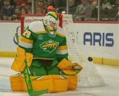 a hockey goalie sitting on the ice in front of an net