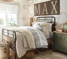 a bed room with a neatly made bed next to a window and a wooden sign on the wall