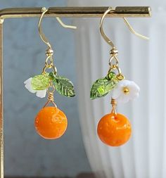 Lovely earrings feature 9 mm Czech glass orange bead, plastic leaves and white flowers.  On gold plated over brass ear wires and chain.  Delightful to wear! Earring length: 37 mm Please leave at the Personalization box of your necklace length if you purchase the necklace. Purchase over $40 enjoys free shipping! Coupon code 'freeshipping1'. Free Gift Wrapping on request - All items that are gift wrapped come in with a kraft box with raffia string and blank writing card.  Please leave a note if yo Orange Drop Earrings For Gift, Orange Earring Jewelry Gift, Orange Dangle Flower Earrings With Ear Wire, Orange Dangle Flower Earrings For Gift, Orange Dangle Flower Earrings Gift, Whimsical Handmade Orange Earrings, Orange Flower-shaped Earrings For Gift, Orange Fruit Earrings, Summer Orange Flower-shaped Jewelry