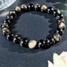 Description: This elegant golden obsidian bracelet is the perfect blend of beauty and meaning. Handcrafted with care, the shimmering golden hues of the obsidian beads catch the light, creating a sophisticated and timeless piece of jewelry. Known for its protective and grounding properties, golden obsidian is more than just a gemstone; it's a connection to strength and positivity. ✨ Features: Material: Natural golden obsidian beads with a unique golden shimmer Bracelet Type: Elastic stretch cord for comfortable wear Size Options: Available in multiple wrist sizes (customizable upon request) ✨ Gemstone Meaning: Golden Obsidian: A powerful protective stone, believed to shield against negativity and provide clarity and focus. Its golden sheen symbolizes illumination and strength, making it ide Golden Obsidian, Obsidian Bracelet, Gemstone Meanings, Natural Stone Jewelry, Energy Healing, Stone Jewelry, Arm Band, Timeless Pieces, Natural Stone