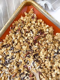 an orange tray filled with granola on top of a table