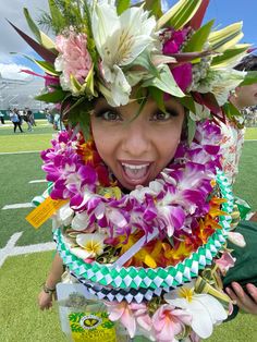 a woman with flowers on her head is posing for the camera at a football game