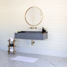 a bathroom with a sink, mirror and towel rack on the wall next to it