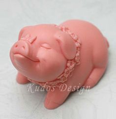 a pink toy pig laying on top of a white surface