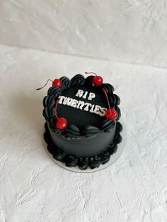 a black cake with the words pir titrizes on it and cherries