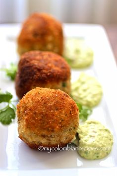 three crab cakes on a white plate with garnishes