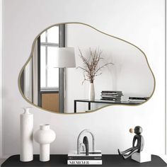 a mirror sitting on top of a table next to a vase