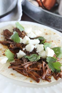 shredded beef and feta cheese on a tortilla