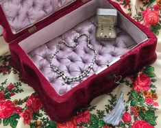 an open red velvet jewelry box on a floral tablecloth