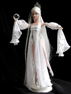 a barbie doll dressed in white with long hair and veil, wearing a tiara