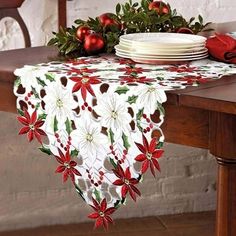 a christmas table runner with poinsettis on it