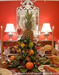 a pineapple christmas tree in the middle of a dining room table with fruit on it