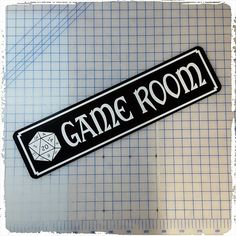 a black and white sticker with the word game room written on it next to a ruler