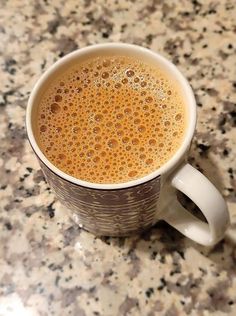 a cup of coffee sitting on top of a counter