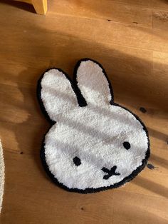 a white rug with a black and white bunny face on it sitting on a wooden floor