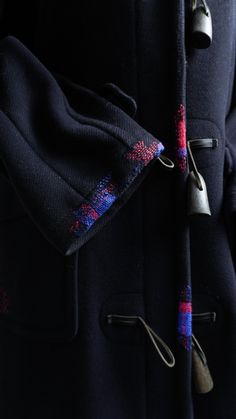 a close up of a coat with scissors attached to the back of it's jacket