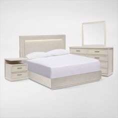 a white bed sitting next to a night stand with two nightstands and a mirror