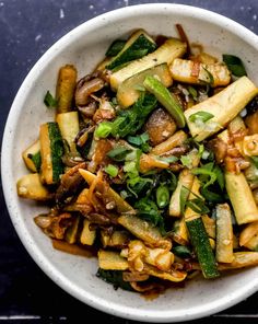 a white bowl filled with vegetables on top of a table