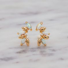 It's time to channel some ethereal magic with these delicate opal cluster earrings. These gorgeous opals flash pink, blue, and green—making these earrings truly mesmerizing. The cluster design creates a timeless look that transitions seamlessly from day to night. The unique marquise shape evokes a sense of nature-inspired beauty, while the iridescence of the opals adds a celestial, otherworldly charm. It's like wearing a constellation on your ears. It's a reminder that we are all made of stardust and magic is ingrained deep within each of us. Crafted with love and intention, the Opal Marquise Stud Earrings are the perfect gift for anyone on your list-or yourself! It's also the best way to honor your favorite Libra with their birthstone. Key Features: Material: High-quality gold-filled with Celestial Magic, Cluster Design, Cluster Earrings, Earring Sale, Opal Gemstone, Stardust, Blue And Green, Nature Inspired, Constellations