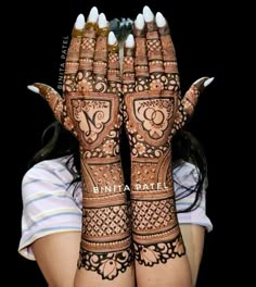 a woman is holding her hands up with henna tattoos