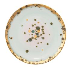 a white and gold plate with dots on it