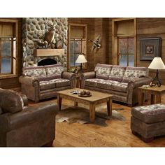 a living room with couches, chairs and tables in front of a stone fireplace