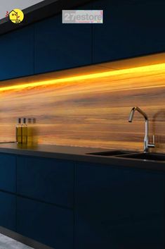 a modern kitchen with blue cabinets and counter tops, along with an orange painted backsplash