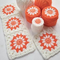 an orange and white crocheted table runner with balls of yarn next to it