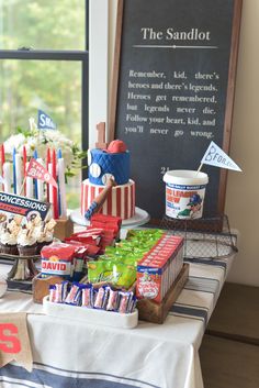 a table filled with candy and candies next to a sign that says the sandlot