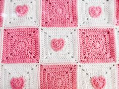 a crocheted blanket with hearts on it is shown in pink and white colors