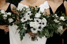 the bridesmaids are holding their bouquets with white and black flowers on them