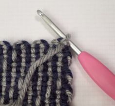 a crochet stitch with a pink handled knitting needle