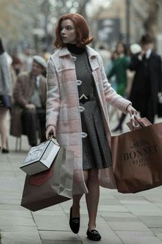 a woman walking down the street carrying shopping bags