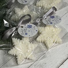 soaps wrapped in plastic and tied with ribbon on top of a wooden table next to pine branches