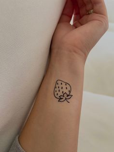 a woman's arm with a small tattoo on the left side of her wrist