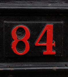 an old black mailbox with red numbers and the number 844 written on it