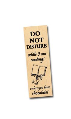 a wooden bookmark that says do not disturb while i am reading unless you have chocolate