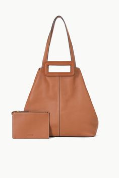 The Grande Tote Bag is a soft, unlined tote with top handles and longer over-the-shoulder straps for versatility. It includes an interior closure on the gussets to bring in the sides of the bag to create a different shape and a removable zip pouch.